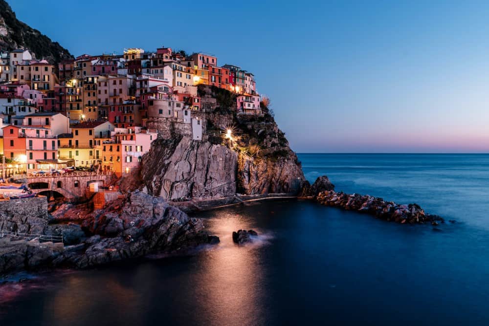Das Dorf Cinque Terre wird in der Abenddämmerung beleuchtet.